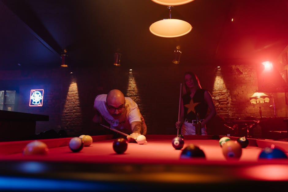 Two people enjoying a thrilling game of pool at a lively bar.